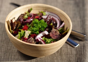 Close-up of spring salad in wooden bowl
