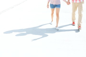 Low section of couple walking on street