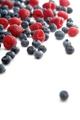 Raspberries and blueberries on white background