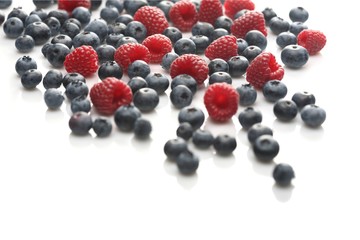 Raspberries and blueberries on white background