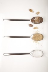 White and brown sugar on spoons