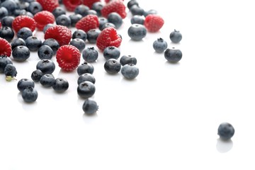 Raspberries and blueberries on white background