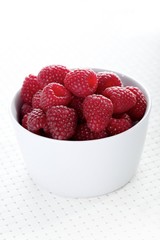 Raspberries in white bowl - close-up