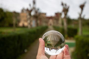 Palace is reflected over a glass ball