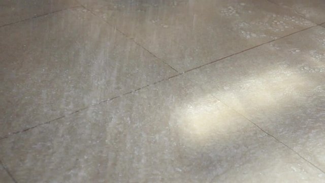 Waterdrops On Floor Tiles ,HD Slow Motion. Water From Shower Head Dropping Down And Splashing On The Bathroom Floor.