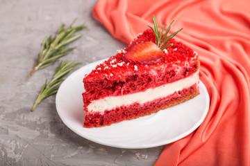 Homemade red velvet cake with milk cream and strawberry on a gray concrete background. side view, selective focus.