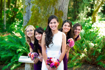 Beautiful biracial young bride smiling with her multiethnic group of bridesmaids