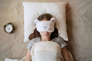 Cute teen girl sleeping in a sleep mask at home              