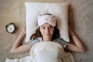Cute teen girl woke up in the morning in a sleep mask at home     