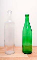 one green glass bottle and one clear glass bottle