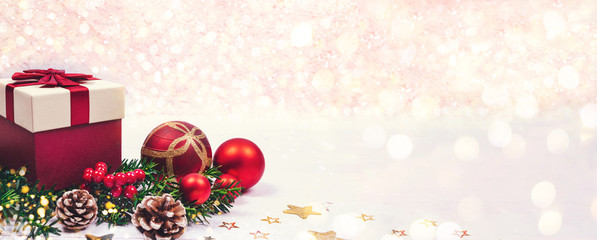 Christmas present, branch of fire tree and decoration toys laid on white background of painted wooden planks with copy space for text. Holiday and New Year concept.