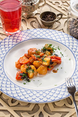 Grilled vegetable garnish with zucchini, onion, pepper and tomato with berry juice on oriental wooden table