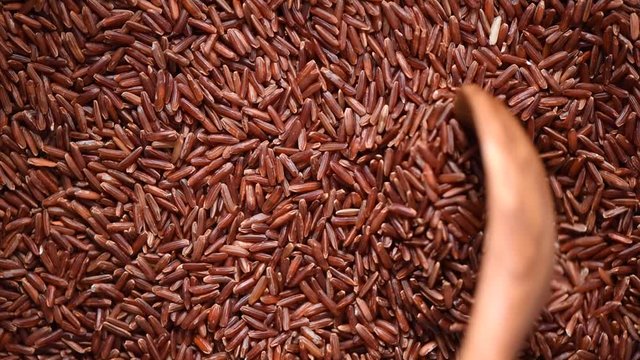 Raw organic rice berry, brown rice mixed texture on rotating background. Food ingredient concept. Top view, healthy lifestyle