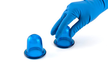 hand in medical glove holding blue anti-cellulite vacuum silicone body jars