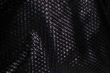 Elegant black leather background with mesh patterns.