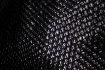 Elegant black leather background with mesh patterns.