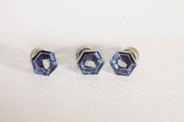 front of three very small blue glass drawer knobs or pulls