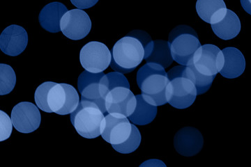 Abstract bokeh background with beautiful shiny festive blue lights creating a magic atmosphere in main color of the year 2020.