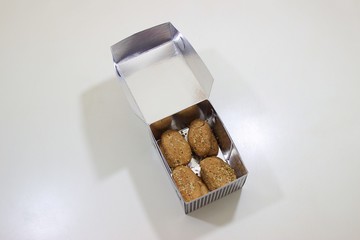 Melomakarona Greek traditional sweet for christmas holiday in a paper box from a bakery as a gift isolated on white background. Top view