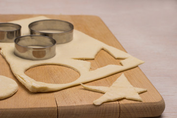 Dough for baking ginger cookies on a cutting board, a form for cookies cut blanks