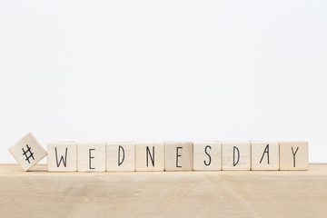Wooden cubes with a hashtag and the word wednesday, social media concept near white background