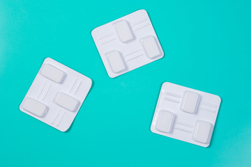 White vaginal antibacterial pills on green background.Candles are soaked in water and injected into vagina to treat candidiasis, thrush, inflammation. Effective modern drug for treatment of diseases