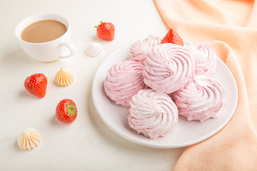 Pink strawberry homemade zephyr or marshmallow with cup of coffee on white wooden background. side view.