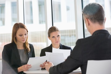 Business people discussing paperwork in office cafeteria