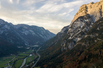 Aerial view of majestic european Alps mountains covered in evergreen pine forest in autumn.