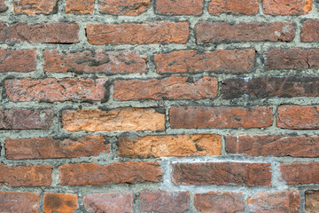 Weathered old red brick background with rough surface.