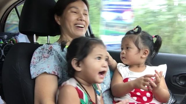 The baby girl danced in the car while traveling with family.