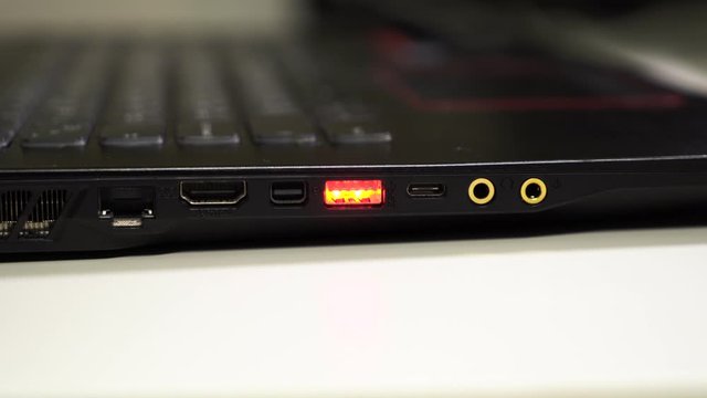 Close up dolly footage of laptop ports with red glow USB port. Modern notebook.