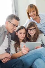 Fototapeta na wymiar Family using digital tablet together in living room