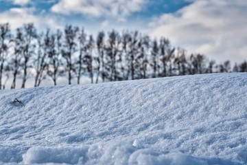 Winter background with pile of snow and blur landscape.