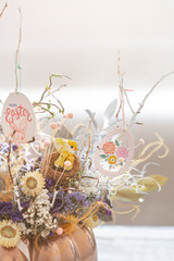 A beautiful Easter arrangement with flowers and eggs .