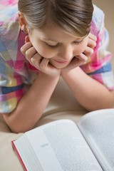 High angle view of girl reading book at home