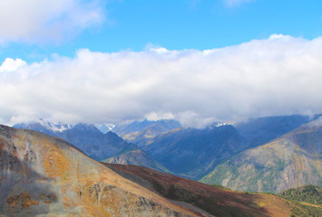 snowy mountain peaks against the sky and a mountain plateau from a height