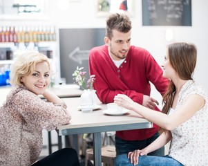 Fototapeta premium Portrait of smiling woman with friend at cafe table