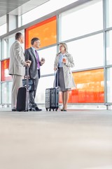 Full length of businesspeople talking on railroad platform