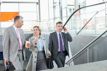 Fototapeta premium Businesspeople walking up stairs in train station