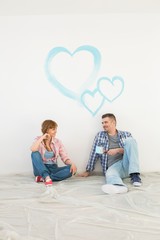 Full-length of mid-adult couple with painted hearts on wall