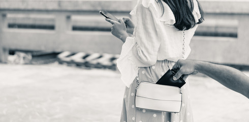 Stealing wallet from the pickpocket from shoulder bag of tourist girl.
