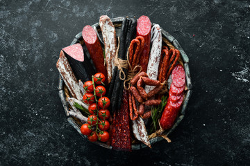 Salami, sausages, spices and meat products in a wooden box. Top view. Free space for your text.