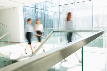 Blurred motion of businesswomen walking at office hallway