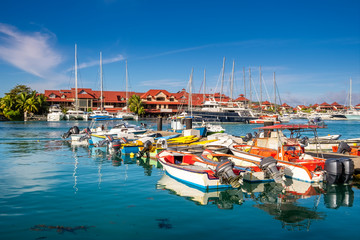 Fototapeta na wymiar Luxury yachts and Boats in sunny summer day at marina of Eden Island, Mahe, Seychelles