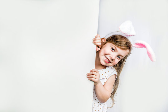Happy cute girl with bunny ears. Easter greeting card background