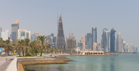 Naklejka premium Doha, Qatar - probably the most notable landmark in Doha, the Corniche is a waterfront promenade extending for seven kilometers along Doha Bay. Here in particular its skyline