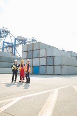 Full-length of workers talking in shipping yard