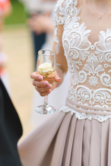bride holding glass with rose and champagne