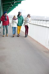 Multiethnic friends walking on footpath during winter